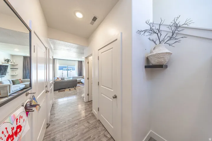 Hallway featuring wood-finish flooring, recessed lighting, and white paneled doors
