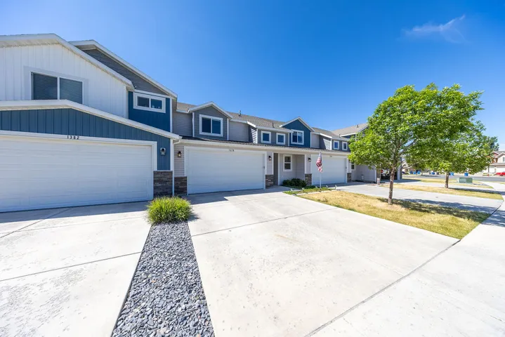 Contemporary townhome-style residences featuring white vertical siding and blue horizontal siding accents