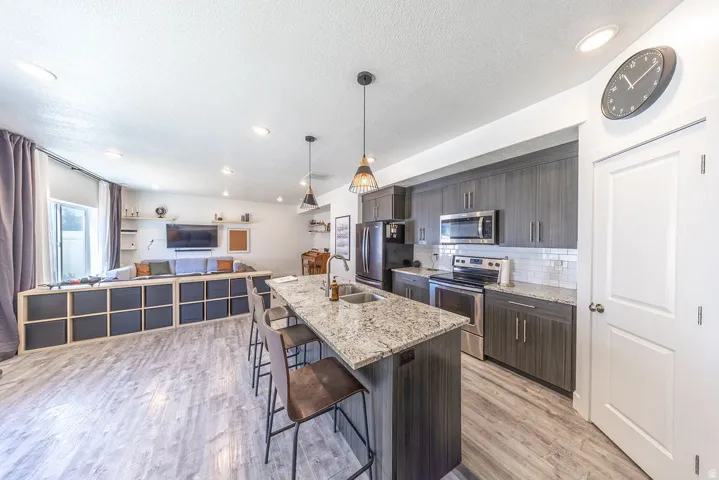Open-concept kitchen featuring wood-finish flooring, recessed lighting, and an island with a light-toned countertop