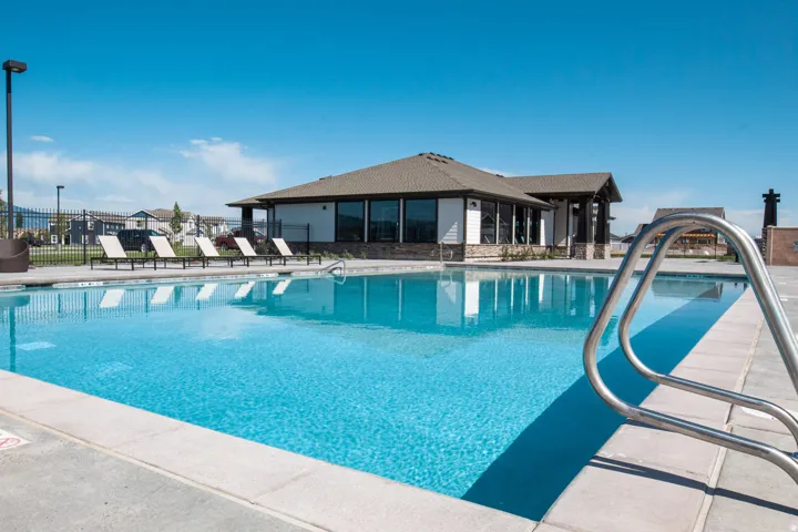 Outdoor swimming pool featuring a concrete deck and metal grab rails