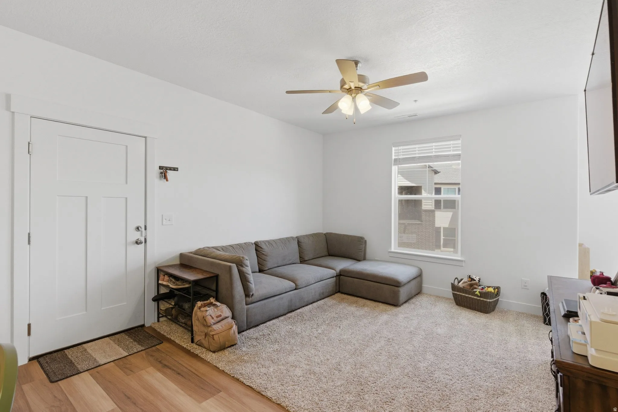 Living area with light-colored walls and carpeted flooring