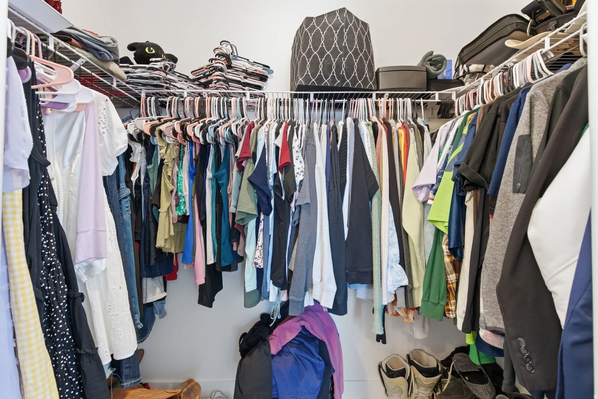 Walk-in closet featuring white wire shelving and hanging rods