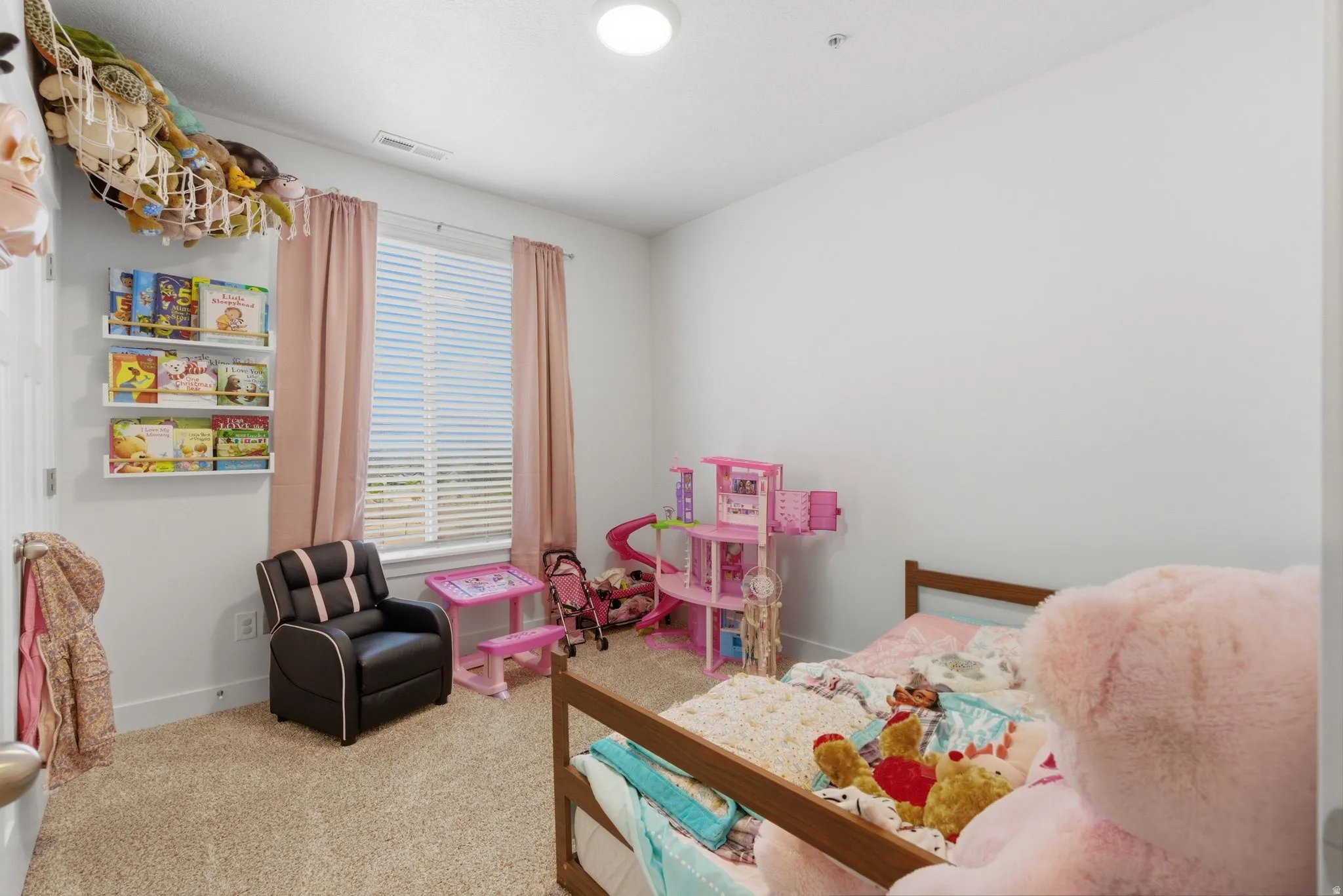 Carpeted interior room with white walls and a single window featuring horizontal blinds