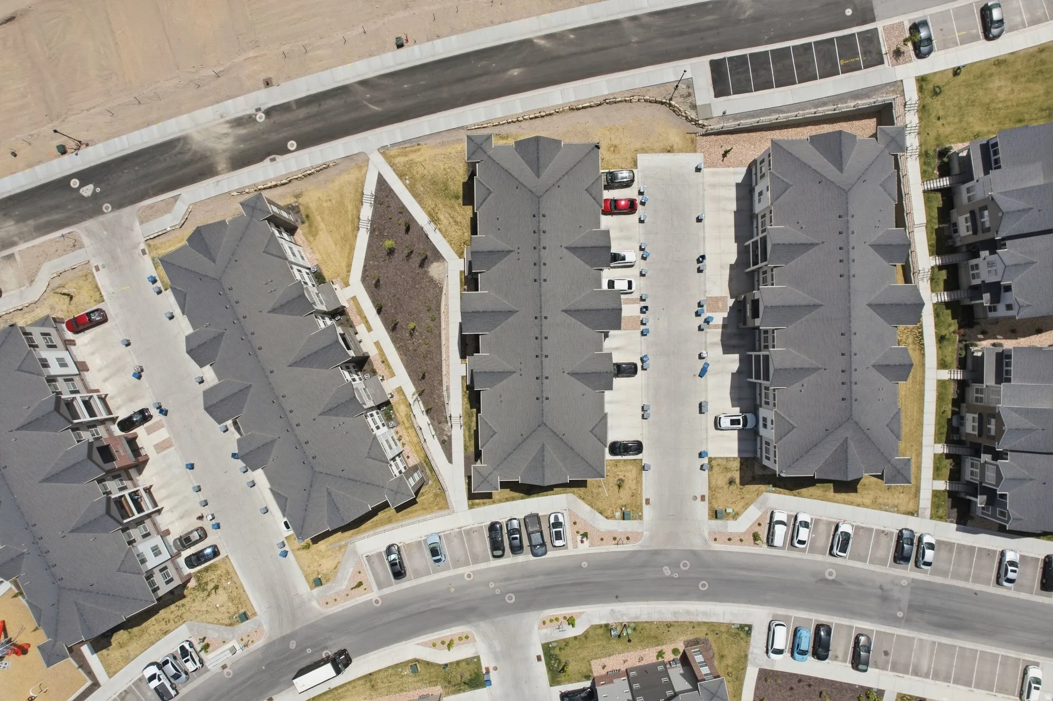 Aerial perspective showcasing multiple multi-story residential buildings with dark gray roofs