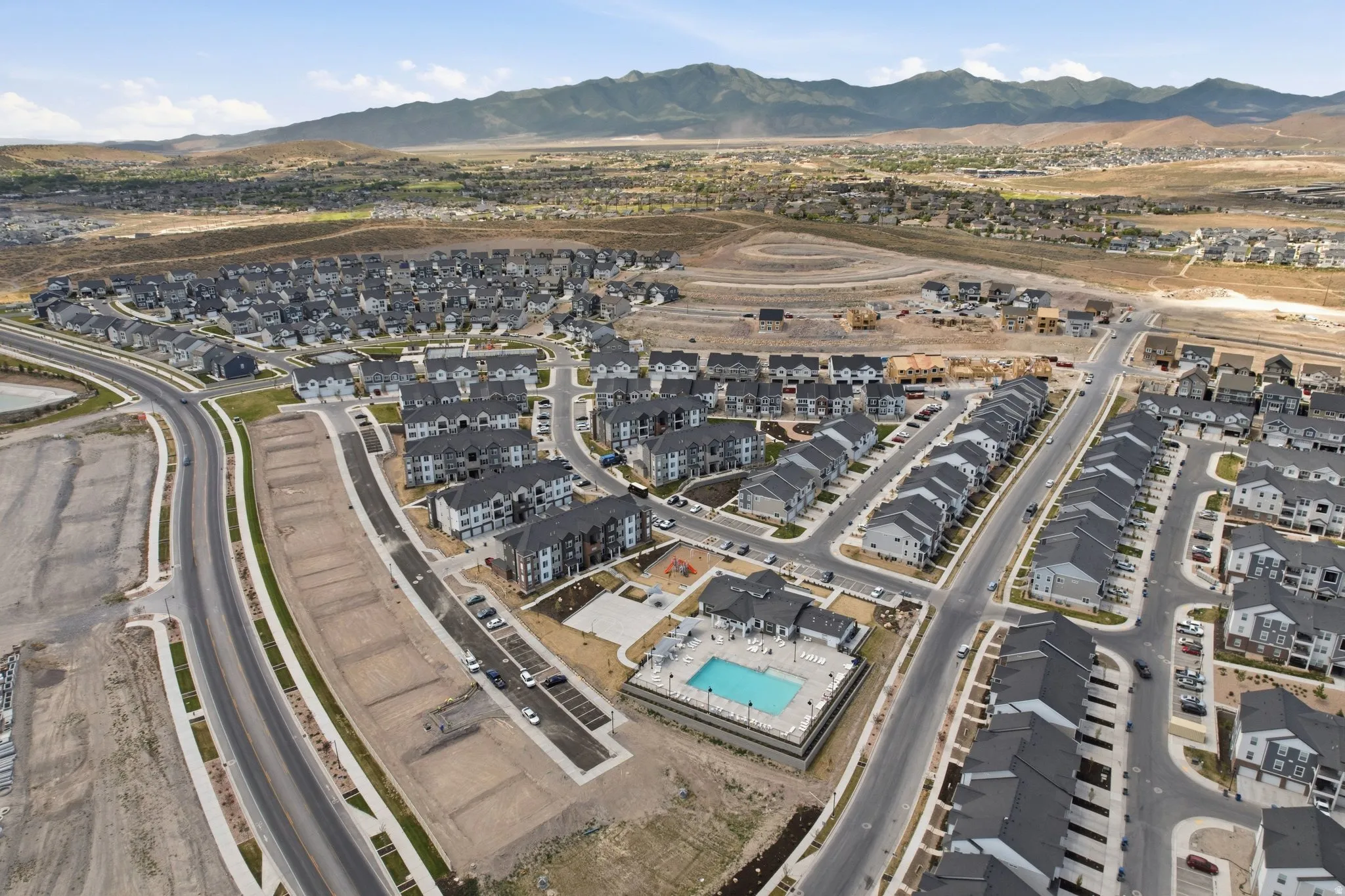 Community featuring varied architectural styles, a central swimming pool, and mountain scenery
