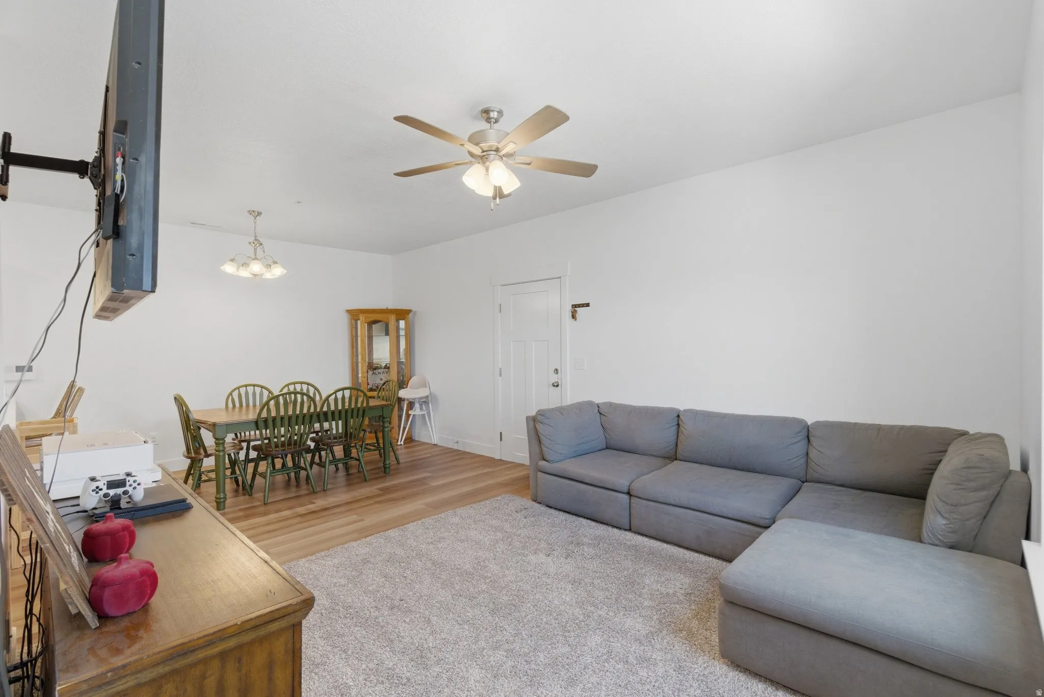 Open-concept living area featuring wood-finish flooring and a ceiling fan