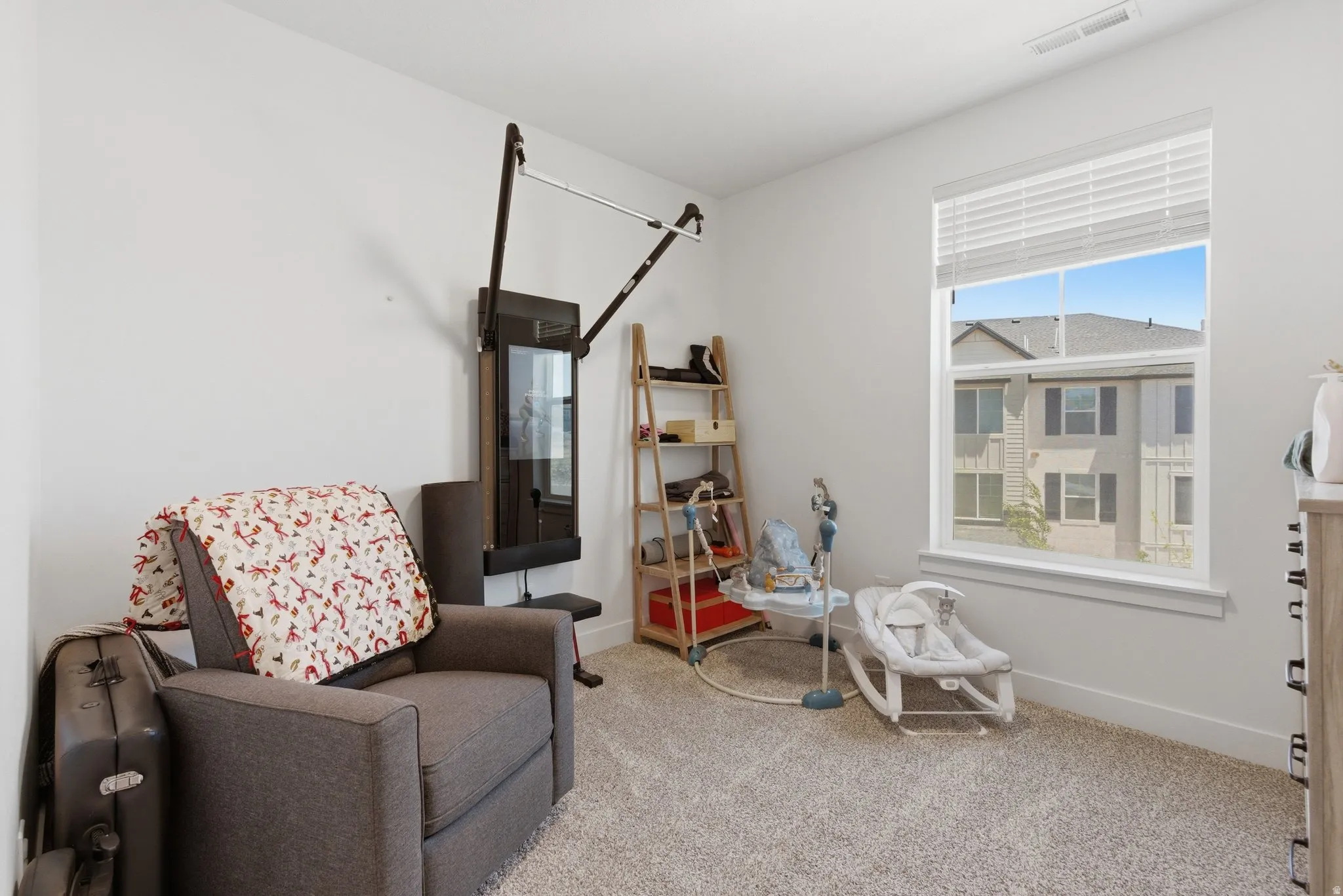Bright room with a large window, neutral wall paint, light-colored carpet, and white window blinds