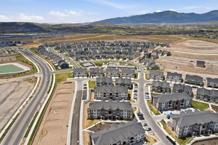 Aerial perspective of a developing residential community, featuring a mix of single-family homes and multi-story apartment buildings
