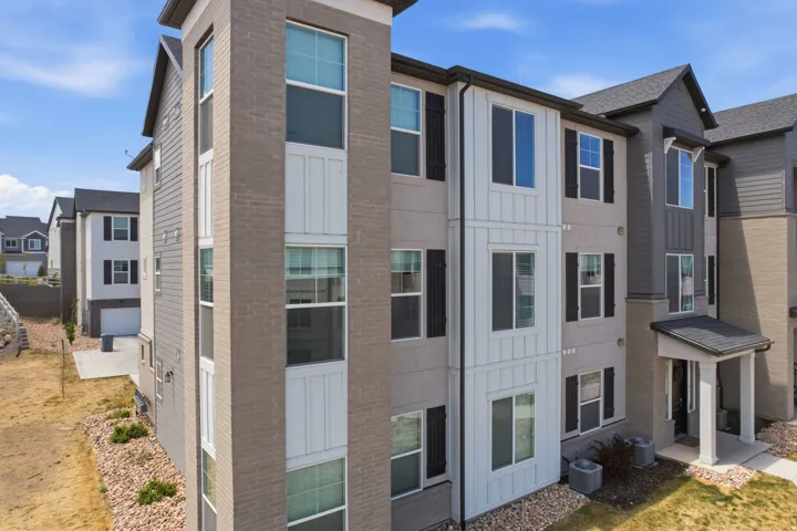 Contemporary multi-story exterior featuring a varied facade of brick, vertical siding, and horizontal siding