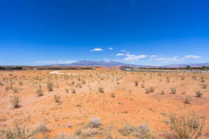Expansive undeveloped desert terrain with scattered low-lying shrubs
