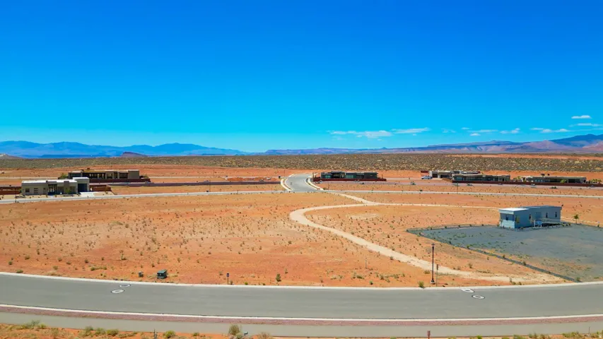 Expansive desert landscape featuring paved roadways and distant mountain ranges