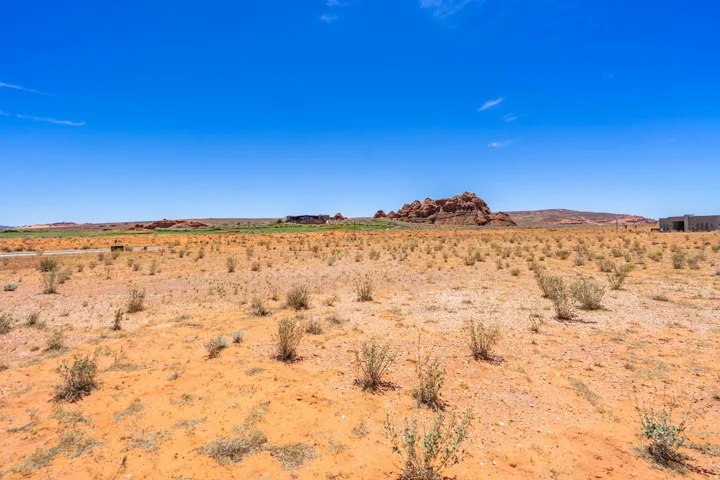 Expansive desert landscape featuring reddish-brown soil and sparse vegetation