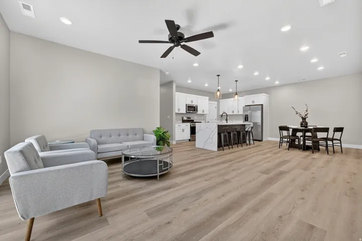 Open-concept living space featuring wood-finish flooring, recessed lighting, and a modern ceiling fan