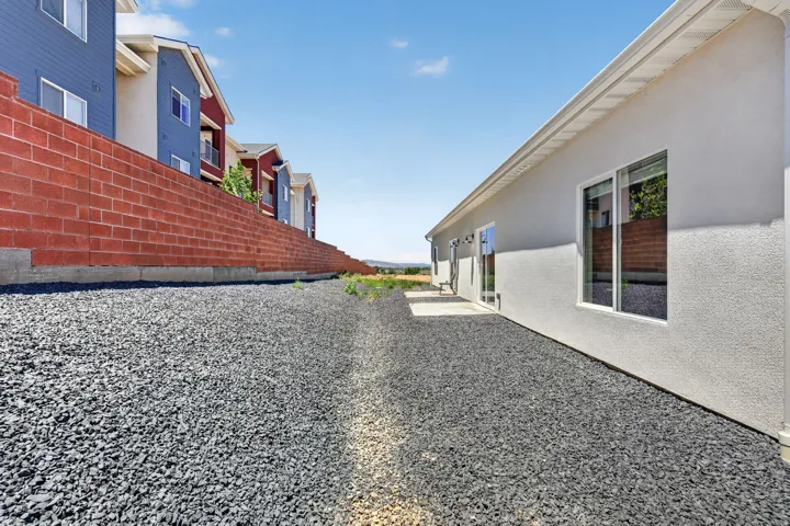 Exterior stucco finish featuring multiple windows and a concrete patio space