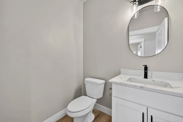 Bathroom featuring a white vanity with a quartz-finish countertop, integrated sink, and matte black faucet