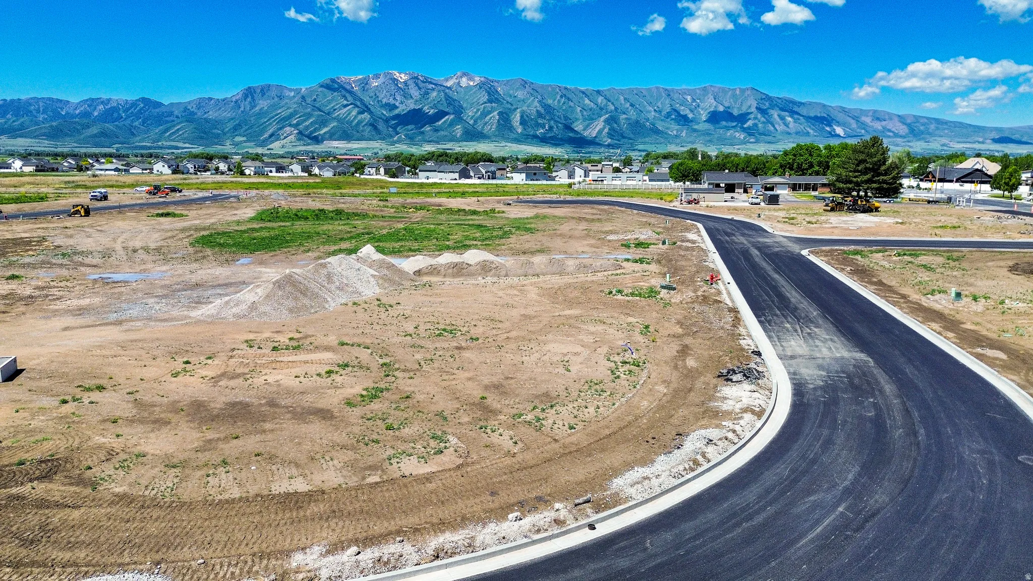 Newly paved asphalt road and concrete curbing in a developing residential area