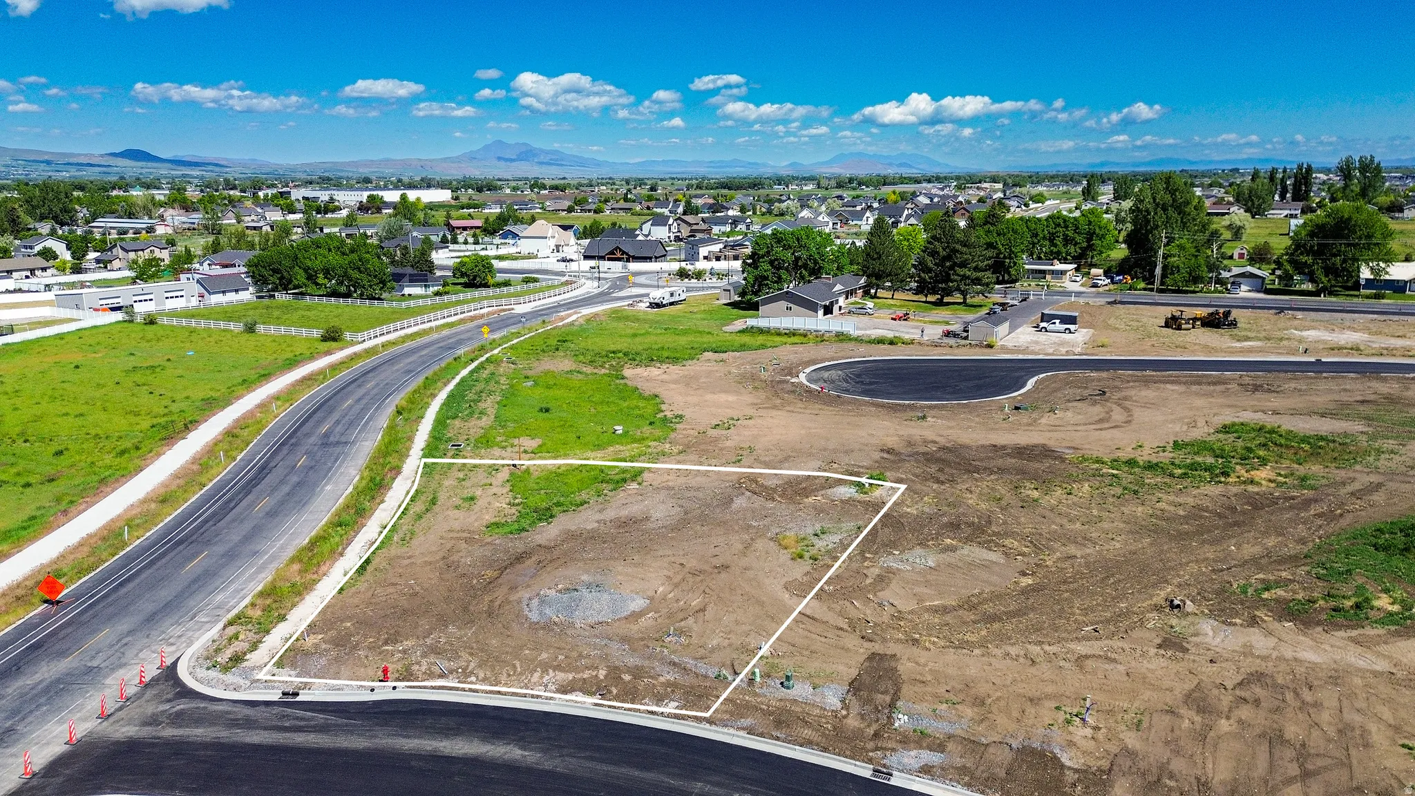 Cleared lot with established road frontage, recently paved street, and developing cul-de-sac