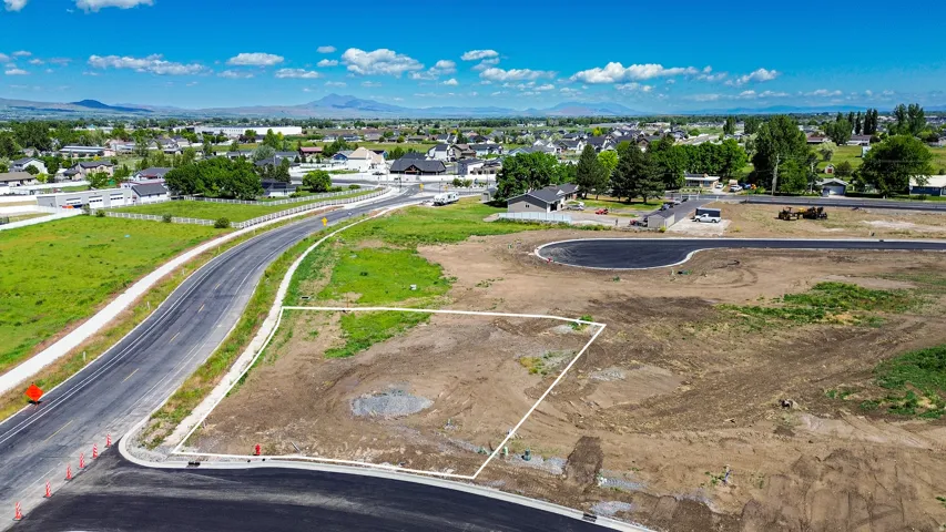 Cleared lot with established road frontage, recently paved street, and developing cul-de-sac