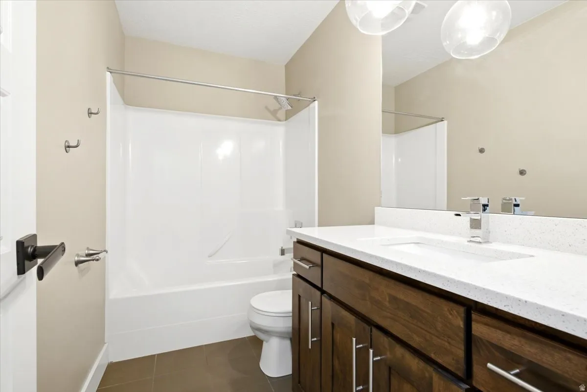 Bathroom featuring a dark wood-finish vanity with a white countertop and integrated sink, chrome faucet, and overhead globe lighting