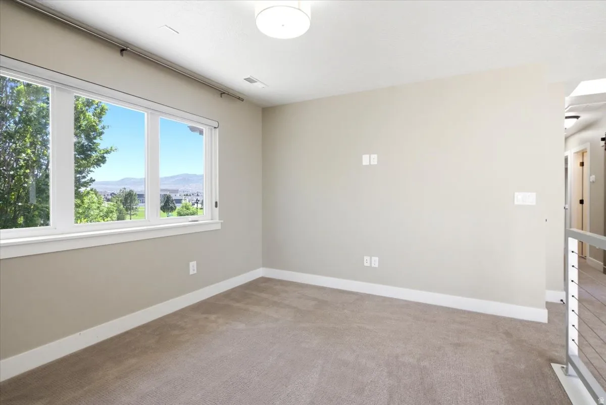 Carpeted room with a multi-pane window and mountain scenery