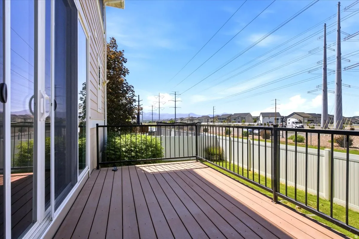Outdoor deck space featuring wood-finish flooring, black metal railing, and direct access to interior via sliding glass doors