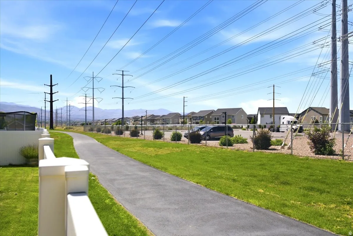 Paved pathway bordered by manicured green lawns