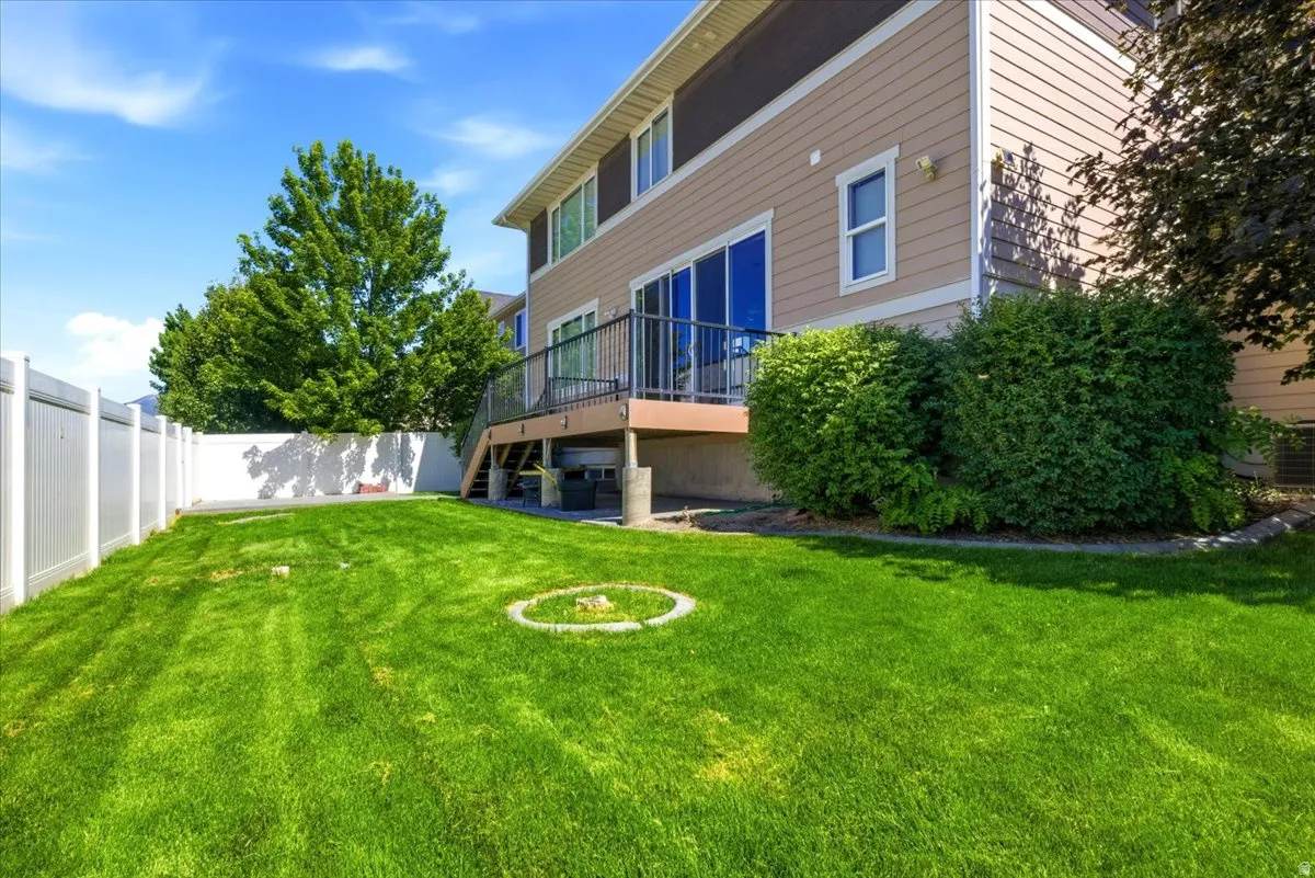 Expansive backyard featuring a manicured lawn, complete with a vinyl privacy fence