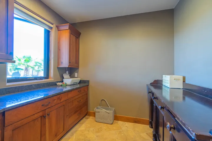 Window-framed counter space featuring stone countertops, integrated base cabinetry, and upper cabinetry