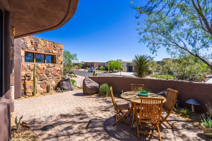 Expansive paver patio with a low stucco privacy wall