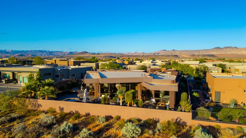Contemporary desert architecture with expansive glass panels, a flat roofline, and an integrated outdoor patio space