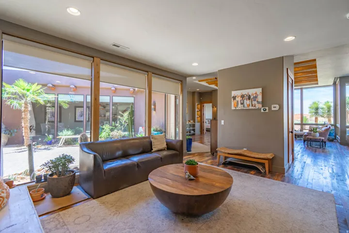 Living area with floor-to-ceiling windows, wood-finish flooring, recessed lighting, and a neutral color palette