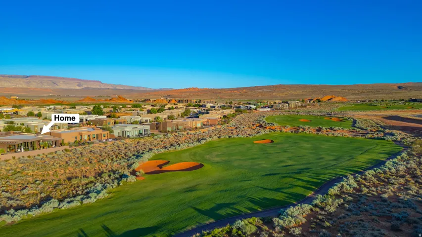 Aerial perspective showcasing the property among a community of homes, bordered by a manicured golf course