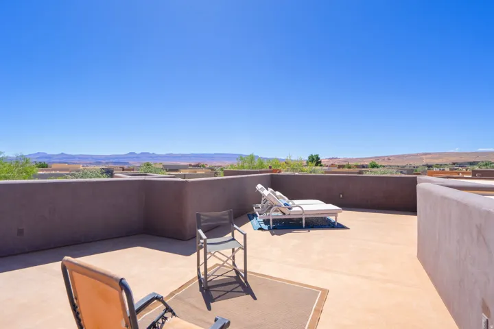 Expansive outdoor patio with sturdy perimeter walls, a broad concrete surface, and a distant desert landscape