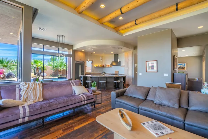 Spacious interior featuring wood-finish flooring, high ceilings with exposed beams, and recessed lighting