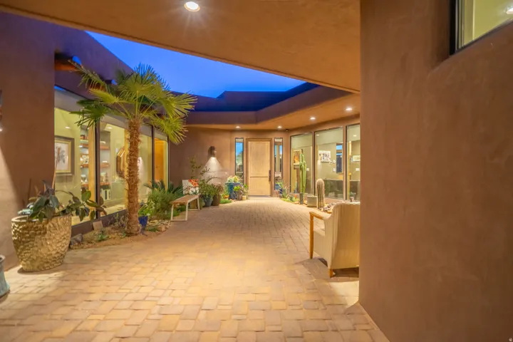 Private courtyard entry featuring paver flooring, stucco walls, and recessed lighting