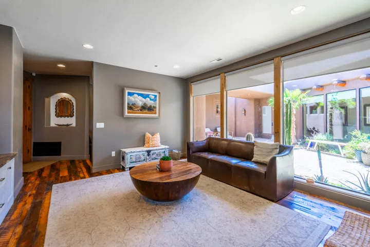 Spacious living area featuring expansive floor-to-ceiling windows, wood-finish flooring, and recessed lighting
