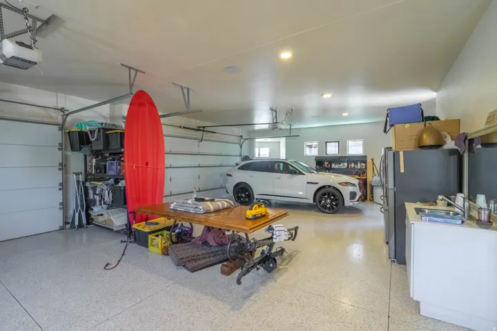 Spacious garage with light-colored speckled epoxy flooring and two automatic overhead doors