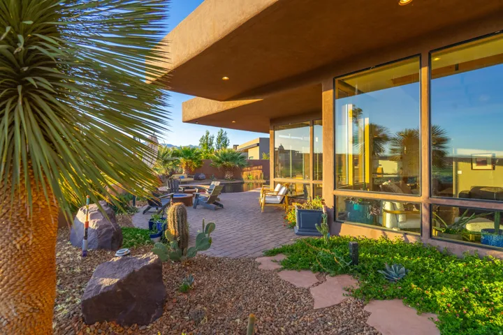 Expansive outdoor patio area featuring a paver surface and a built-in fire pit