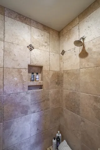Shower stall featuring large format natural stone-look tiling