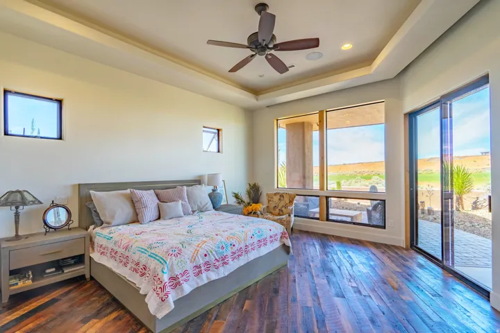 Bedroom featuring wood-finish flooring, a tray ceiling with a ceiling fan, and recessed lighting