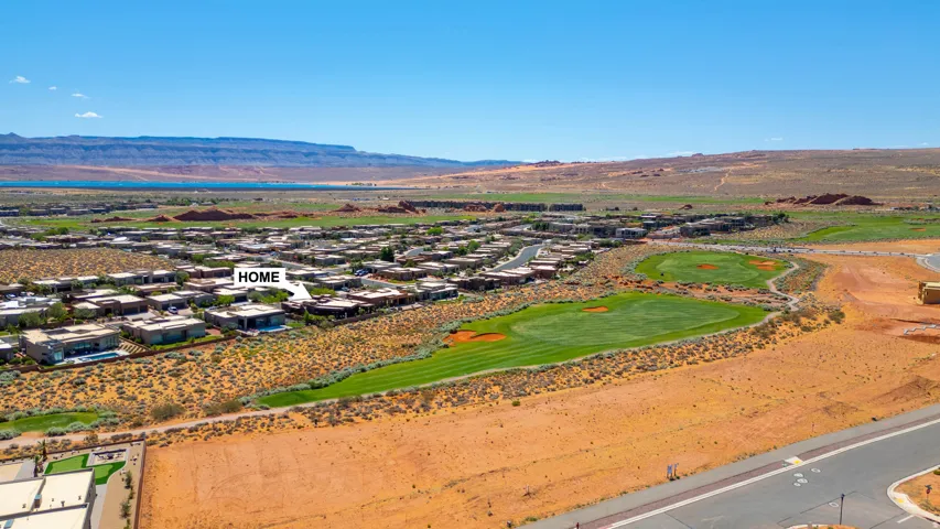 Aerial representation of a residential community featuring golf course frontage, desert landscaping, and distant water body
