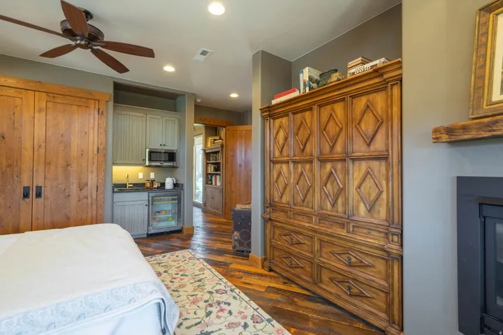 Built-in kitchenette featuring a stainless steel microwave, compact refrigerator, and stone-finish countertop