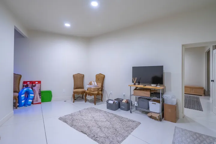 Spacious room featuring light-colored flooring, recessed lighting, and white wall finishes