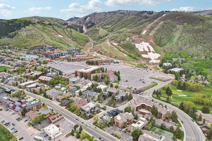 Mountainous terrain backdrop featuring varied slopes with visible ski runs and remnants of snow