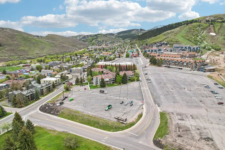 Expansive paved lot with direct road frontage, surrounded by established development and mountainous terrain
