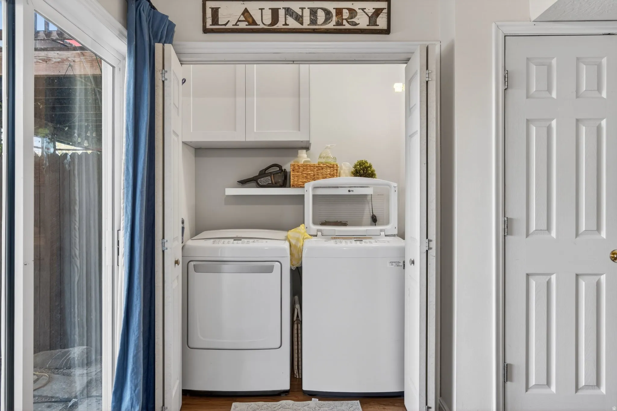 Dedicated laundry area featuring bifold doors, built-in upper cabinetry, and an integrated shelf
