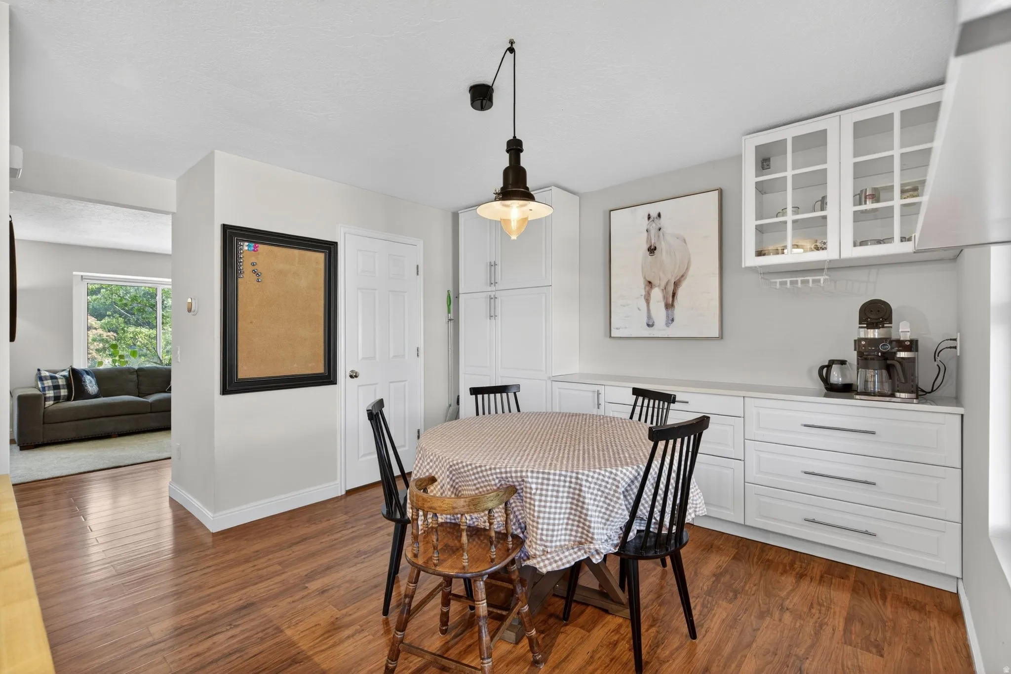 Dining area featuring wood-finish flooring and a contemporary pendant light fixture