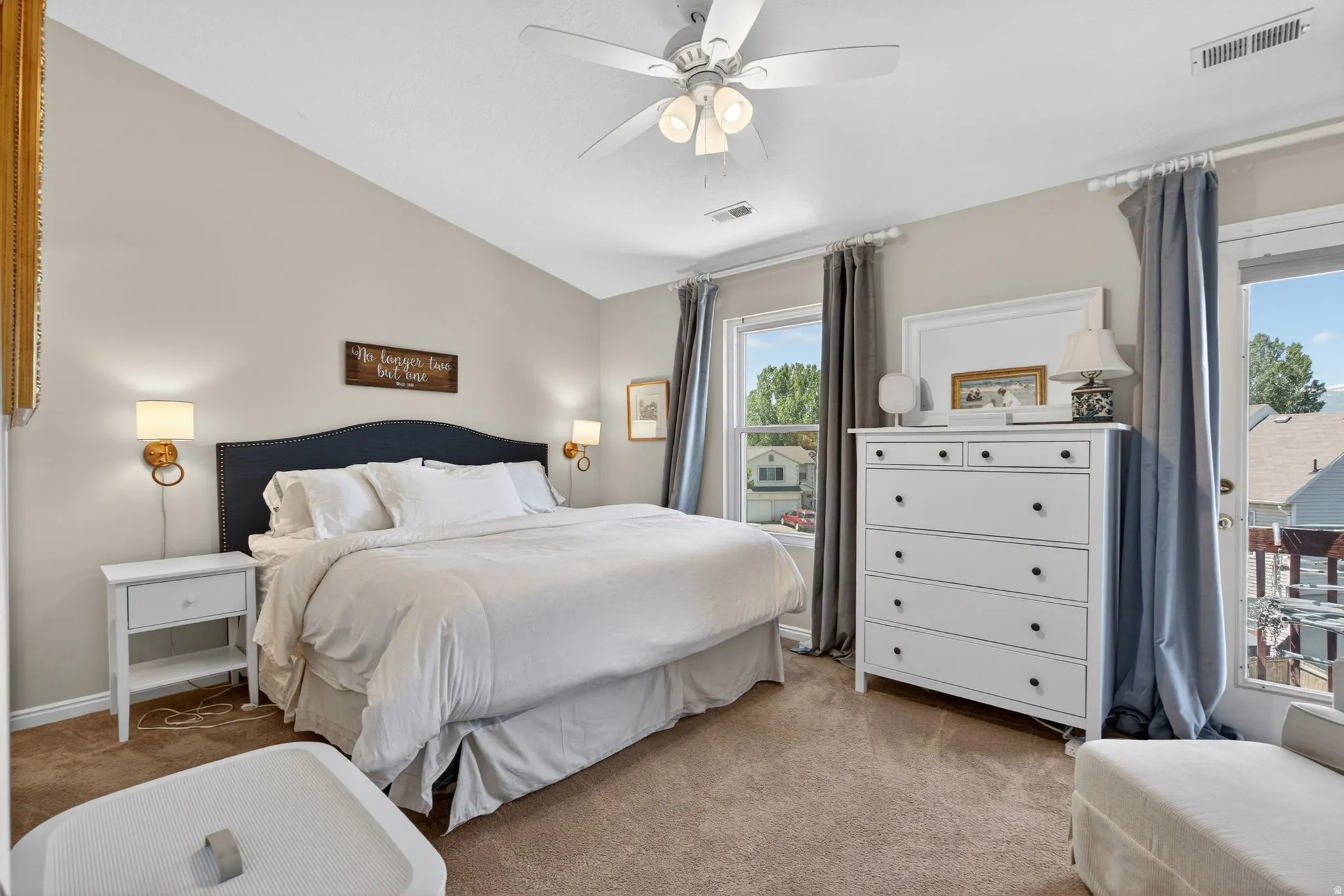 Bedroom featuring a vaulted ceiling, wall-mounted sconce lighting, ceiling fan, and carpeted flooring
