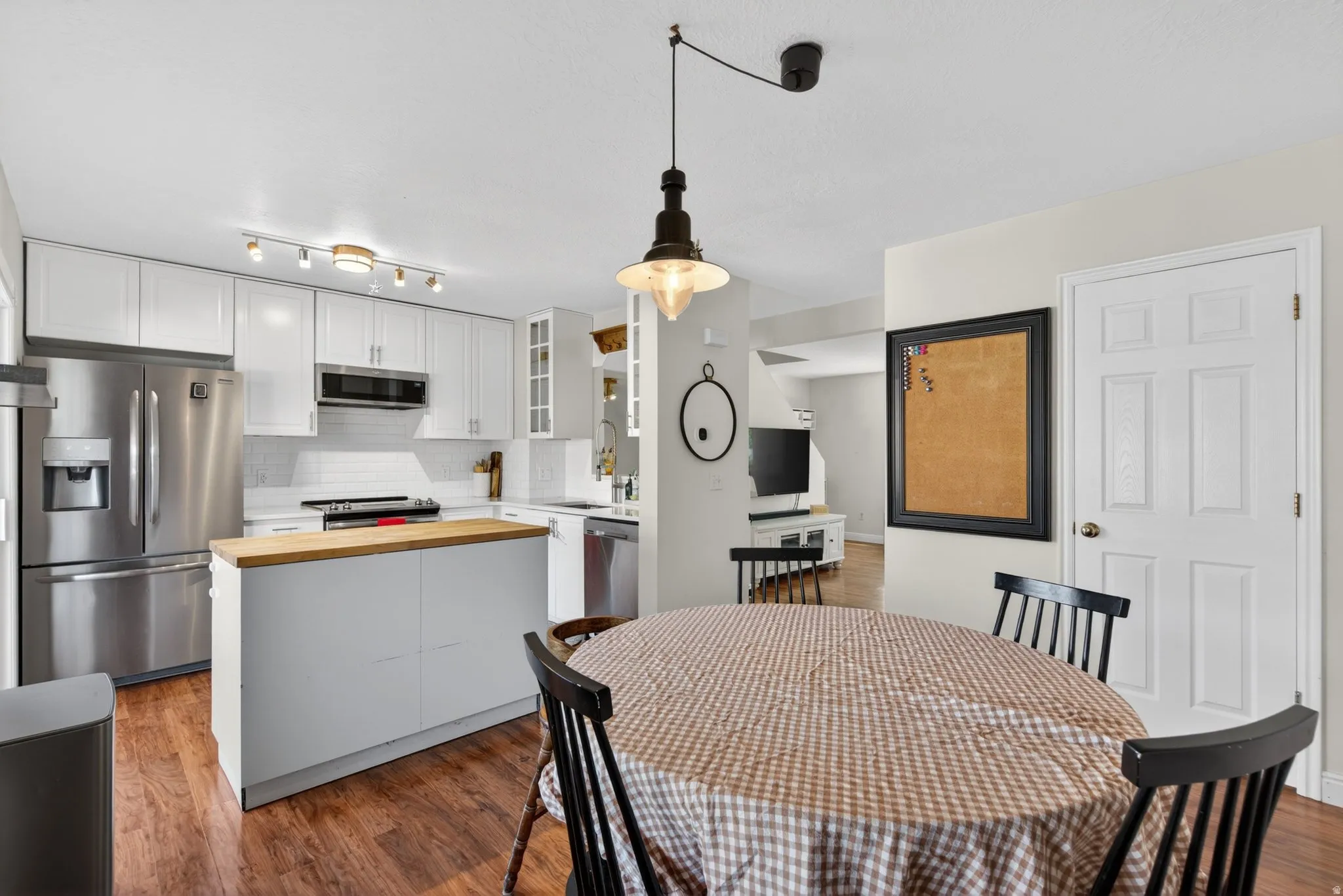 Contemporary kitchen and dining area featuring wood-finish flooring