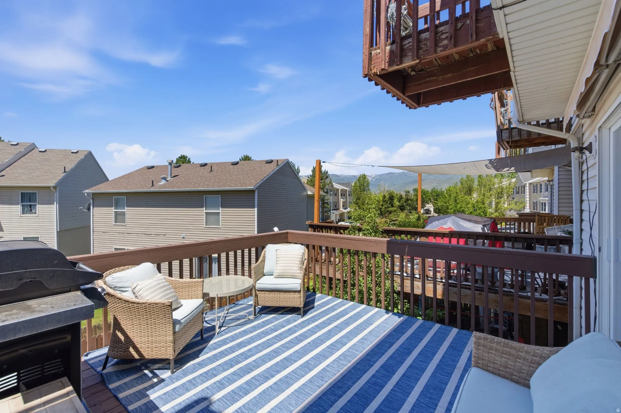 Spacious wooden deck with a built-in outdoor grill and a privacy lattice